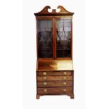 A Regency and later mahogany bureau bookcase, with a blind fret work swan neck pediment above a pair