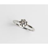 A diamond solitaire ring, the central round brilliant cut diamond weighing approx. 0.73 carats,