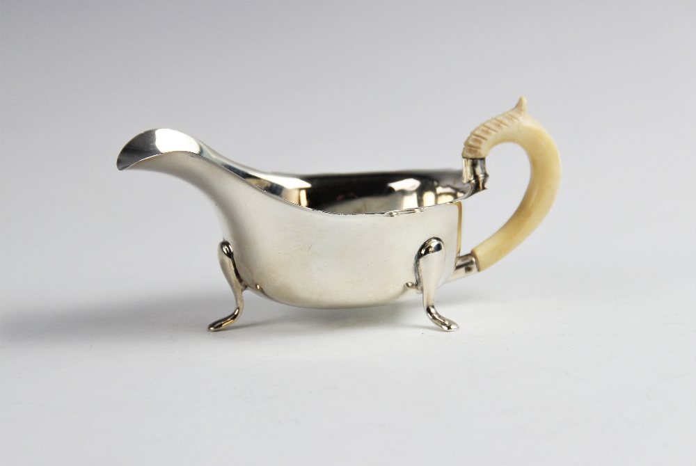 A sauce boat with ivory handle by Emile Viner, Sheffield 1940, of typical form with shaped rim on