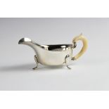 A sauce boat with ivory handle by Emile Viner, Sheffield 1940, of typical form with shaped rim on