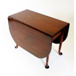 A George III mahogany drop leaf dining table, the rectangular drop leaf top with rounded corners,