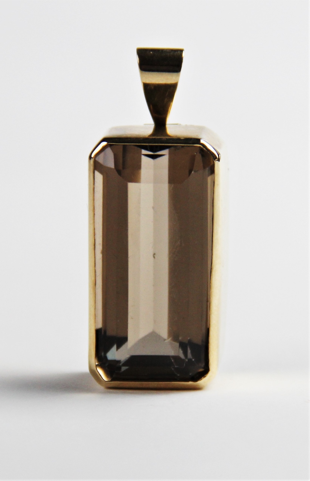 A 9ct smoky quartz pendant, the central rectangular emerald cut quartz measuring 30mm x 15mm, set to - Image 4 of 5
