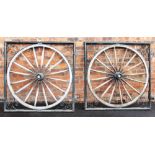 A pair of rustic cartwheel gates, each constructed with a fifteen spoke wooden cartwheel mounted
