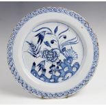 An 18th century tin glaze Delft plate, the blue and white circular charger decorated centrally