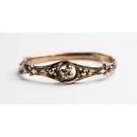 A Victorian yellow metal hinged bangle, the front section designed as a three-leaf clover to a