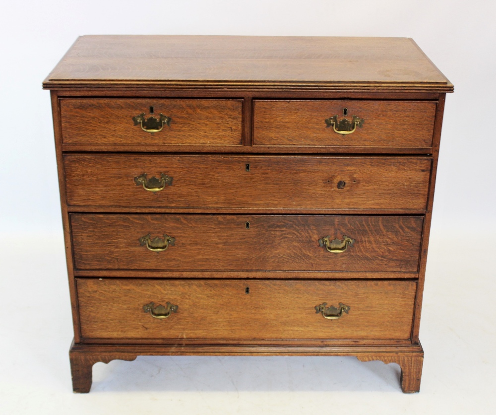 A George III honey oak chest of drawers, the rectangular top with a reeded edge, above two short and