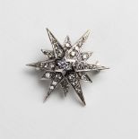 A Victorian style diamond and 18ct gold starburst pendant/brooch, the central round brilliant cut