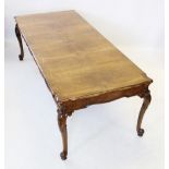 A Queen Anne style walnut dining table, mid 20th century, the rectangular moulded and segmentally