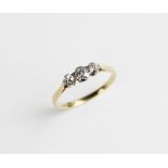 A diamond three stone ring, the central oval old cut diamond measuring 4mm x 3mm x 2.5mm, with a