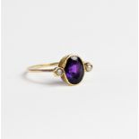 An amethyst and pearl dress ring, comprising a central oval mixed cut amethyst measuring 9mm x