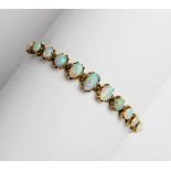 An opal line bracelet, comprising eleven oval opal cabochons measuring between 5mm x 4mm and 10mm