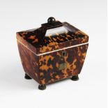 A Regency tortoiseshell tea caddy of sarcophagus form, opening to ivory banding and a pair of