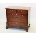 A George III walnut chest of drawers, the rectangular moulded top with rounded front corners,