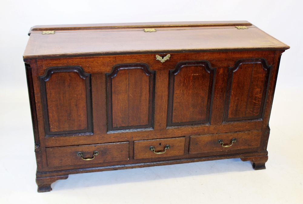 A George III oak mule chest, the rectangular hinged top above four fielded panels flanked by