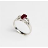 A ruby and diamond 18ct gold ring, comprising a central oval mixed cut ruby measuring approx. 7mm
