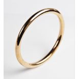 A 9ct gold tubular slave bangle by S Ward & Sons, Chester 1920, 9cm diameter, weight 16.7gms