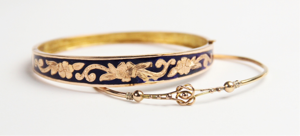 A blue enamelled yellow metal bangle, the oval form tapering bangle with blue enamel and engraved