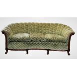 An Edwardian walnut framed kidney shaped sofa, covered in fish scale pattern fabric, the scalloped