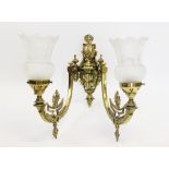 An Edwardian twin branch gilt brass wall sconce, converted from gas, with two branches issuing from