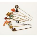 An assortment of Victorian and later stick pins, to include a coral set example, 8cm long, a