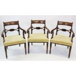 A set of six George IV mahogany elbow chairs, each with a concave top rail above reeded down swept