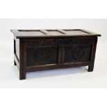 An 18th century oak coffer, with an inverted three panel top above a guilloche carved frieze and two