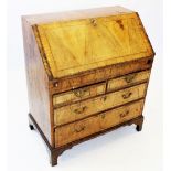 An early 18th century figured walnut bureau, the cross banded fall front with inlaid stringing,