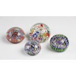 Four paperweights, comprising: a millefiori example of close concentric design, 7.5cm diameter, a