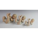 A set of three graduated Gebruder Heubach piano dolls, each modelled playfully on their back,