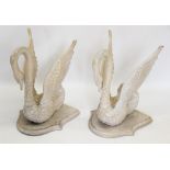 A pair of carved limed wooden swan figures, 20th century, modelled wings raised and mounted upon a