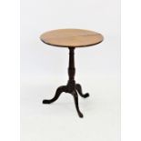 A George III oak tripod table, the circular tilt top raised upon a ring turned baluster column