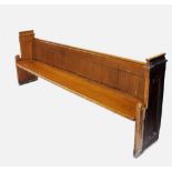 A Victorian pitch pine church pew, the end supports with a pagoda type top rail above Gothic