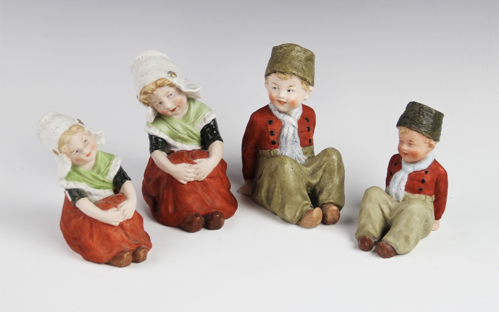 Two graduated pairs of Gebruder Heubach Dutch children, each modelled seated with their hands upon