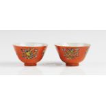 A pair of Chinese porcelain orange ground teabowls, 20th century, each externally decorated with