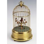 A 20th century French lacquered brass bird automaton, the bird within a domed cage and supported