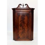 A George III mahogany straight front hanging corner cupboard, the twin swan neck broken pediment