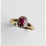 A ruby and diamond 9ct cluster ring, comprising a central oval mixed cut ruby measuring 6mm x 4mm,