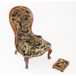 A Victorian mahogany framed balloon back nursing chair, covered in embossed foliate fabric with a