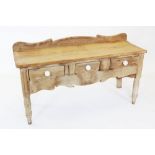 A Victorian pine serving table/dresser, with a shaped raised back above a rectangular slab top and