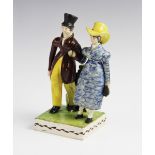 A George III pearlware figural group, early 19th century, modelled as a fashionably dressed lady and