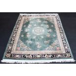 A Chinese embossed wool rug, the central foliate medallion on an olive green ground,