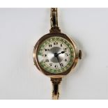 A vintage 9ct gold lady's wristwatch, the round silvered dial with engine turned decoration and