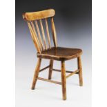 An early 20th century child's elm and beech wood stick back chair, the concave top rail on slender