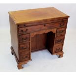 A George III mahogany kneehole desk, the rectangular moulded top above a sliding brushing tray and a