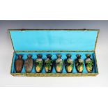 A cased set of seven Japanese cloisonné vases, 20th century, illustrating the process of cloisonné