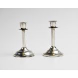 A near pair of late Victorian novelty silver miniature candlestick, each of plain polished form on