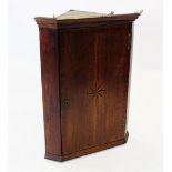 A George III straight front hanging corner cupboard, the single door raised upon later 'H' brass