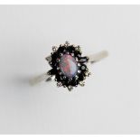 An opal, sapphire and diamond 18ct gold cluster ring, comprising a central oval opal cabochon