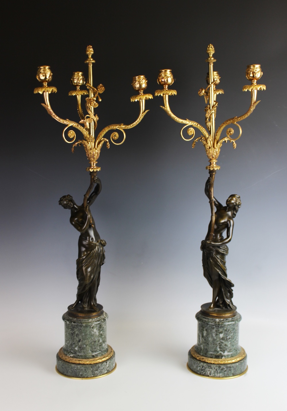 A pair of bronze and gilt metal figural candlesticks, 19th century, each designed as a classical