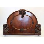 A Victorian mahogany bed, the arched head and foot boards applied with carved fruit and scrolling